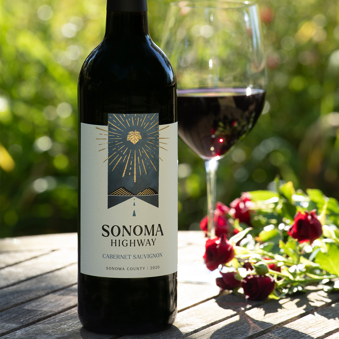 Sonoma Highway Cabernet Sauvignon bottle shot with a poured glass of wine in an outdoor table setting